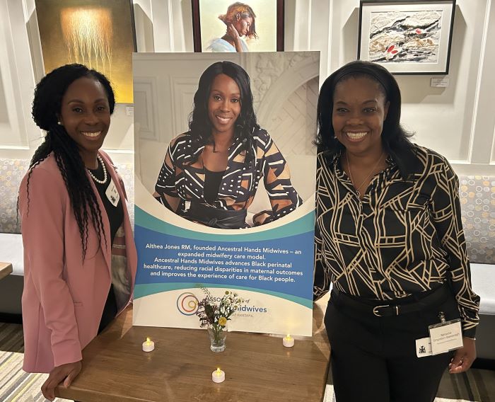 A-O-M President Althea Jones and midwife Natasha Singleton-Bassaragh with a poster featuring Althea's picture.